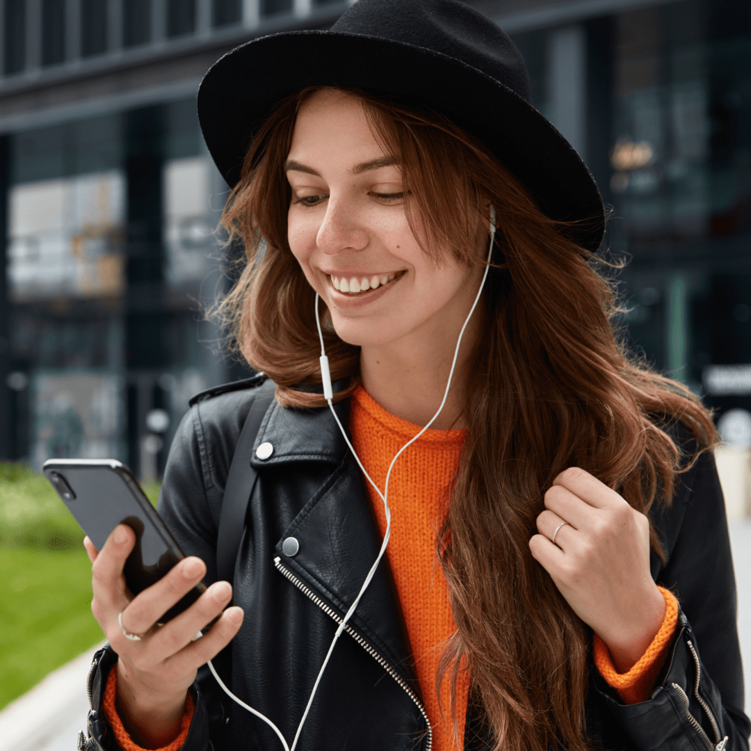 A era do áudio, simbolizada po uma pessoa segurando seu smartphone usando phones de ouvido